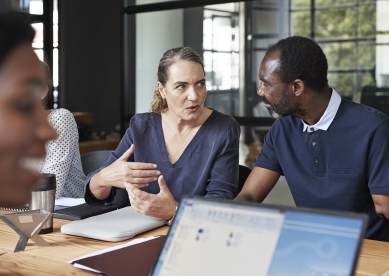 Two coworkers having conversation at table